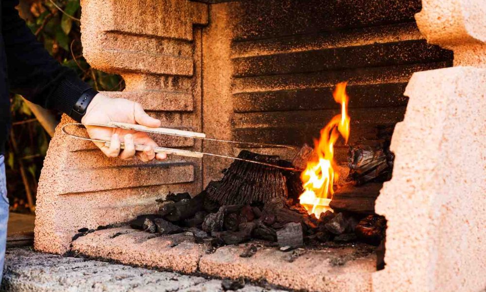 close-up-person-s-hand-burning-firepit (1)