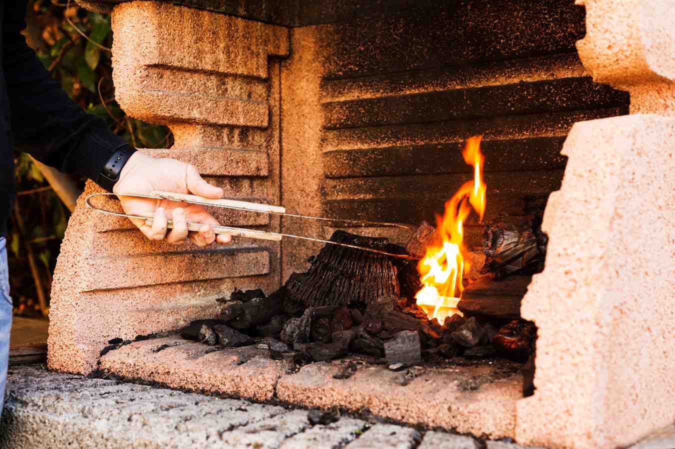 close-up-person-s-hand-burning-firepit (1)
